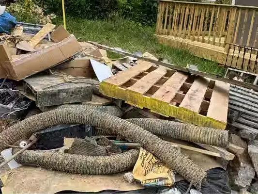 Pallets, lumber and debris piled in a backyard