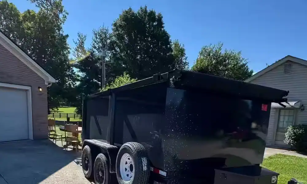 Black dump trailer parked on a residential driveway