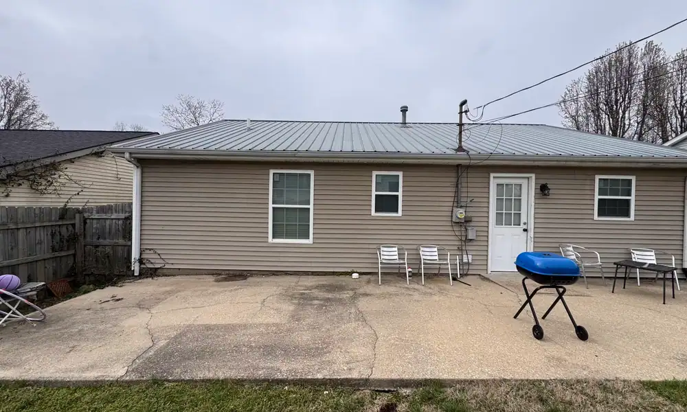 House with a metal roof above a concrete patio